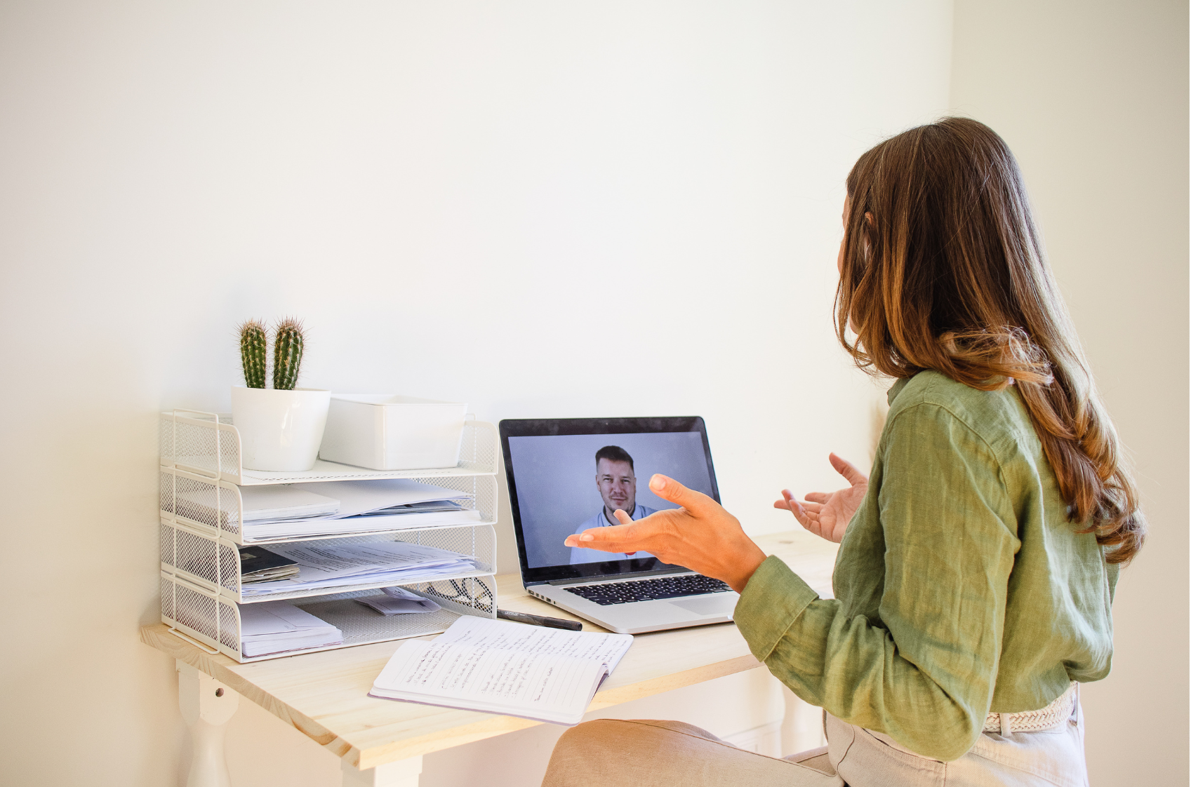 A woman having a video call on her laptop while a man is visible on the screen